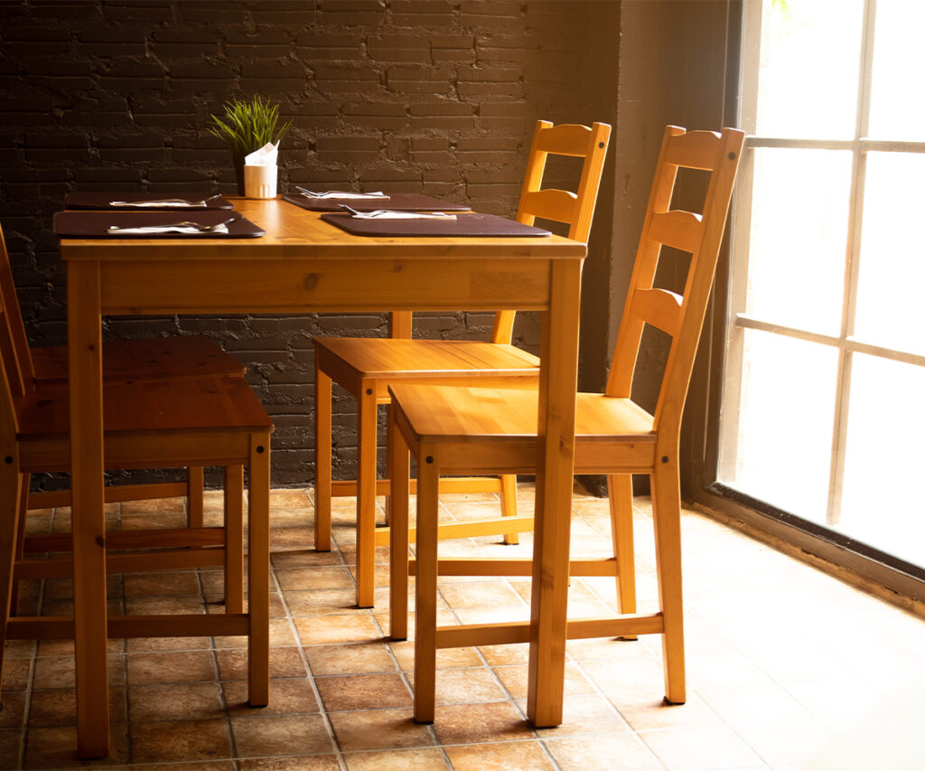 Sunlit dining set near large windows in a bright room